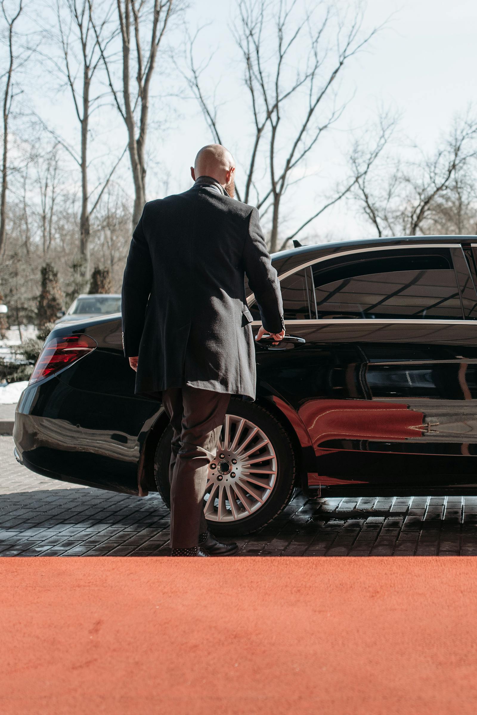 Executive approaching luxury black car